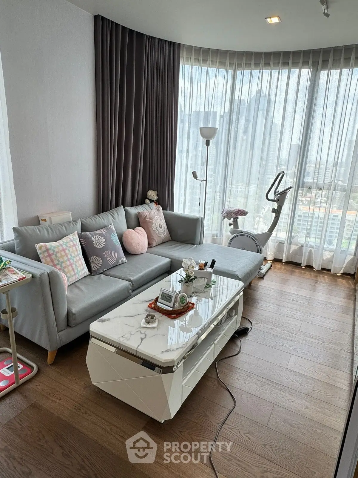 Modern living room with large windows and stylish decor in a high-rise apartment.