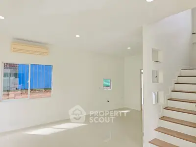 Bright and spacious modern living room with staircase and large window