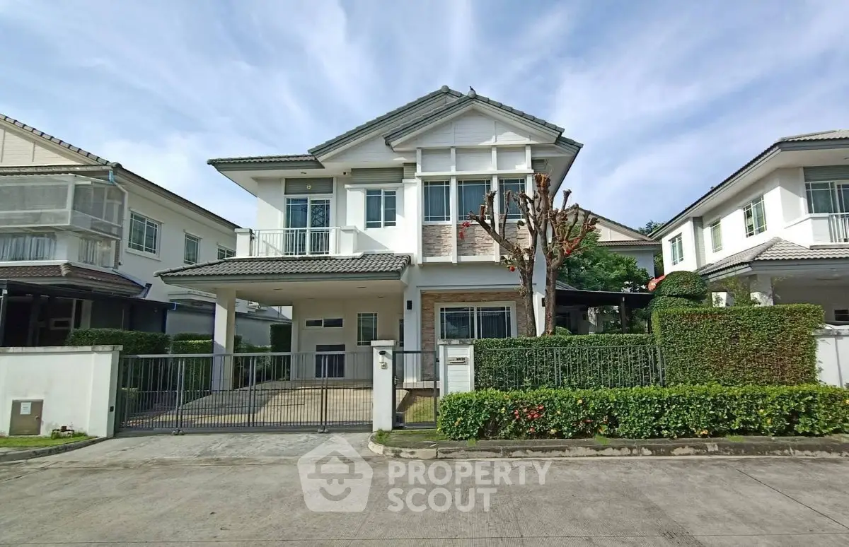 Elegant two-story house with manicured garden and spacious driveway in a serene neighborhood.