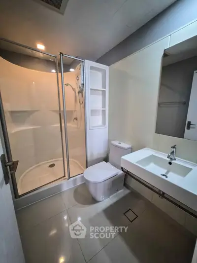 Modern bathroom with sleek shower and contemporary fixtures in a stylish apartment.
