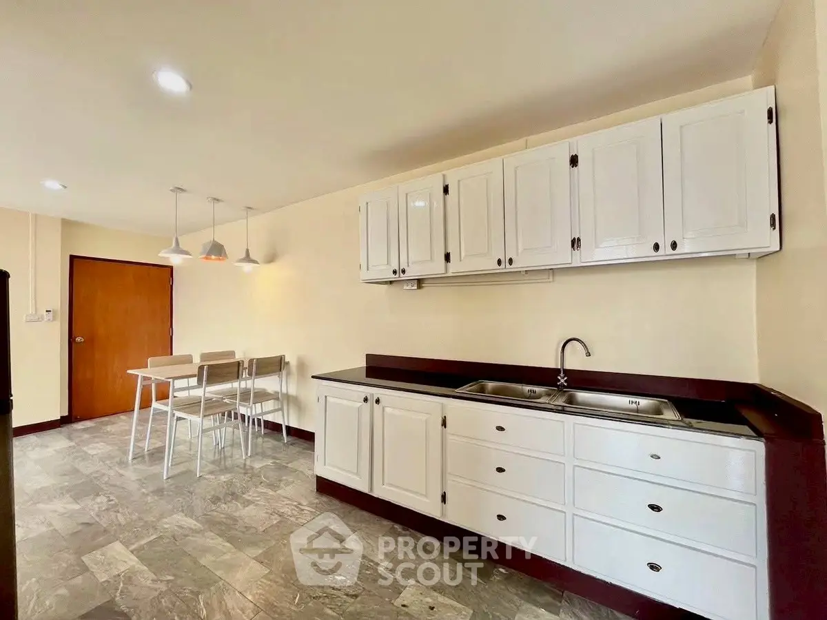 Spacious kitchen with modern cabinets and dining area, perfect for family gatherings.
