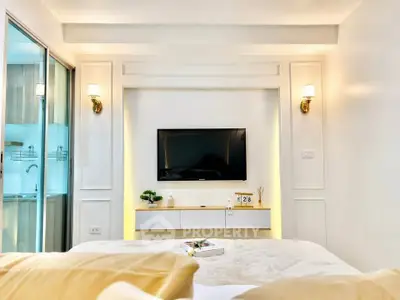 Modern bedroom with wall-mounted TV and elegant lighting, showcasing a cozy and inviting atmosphere.