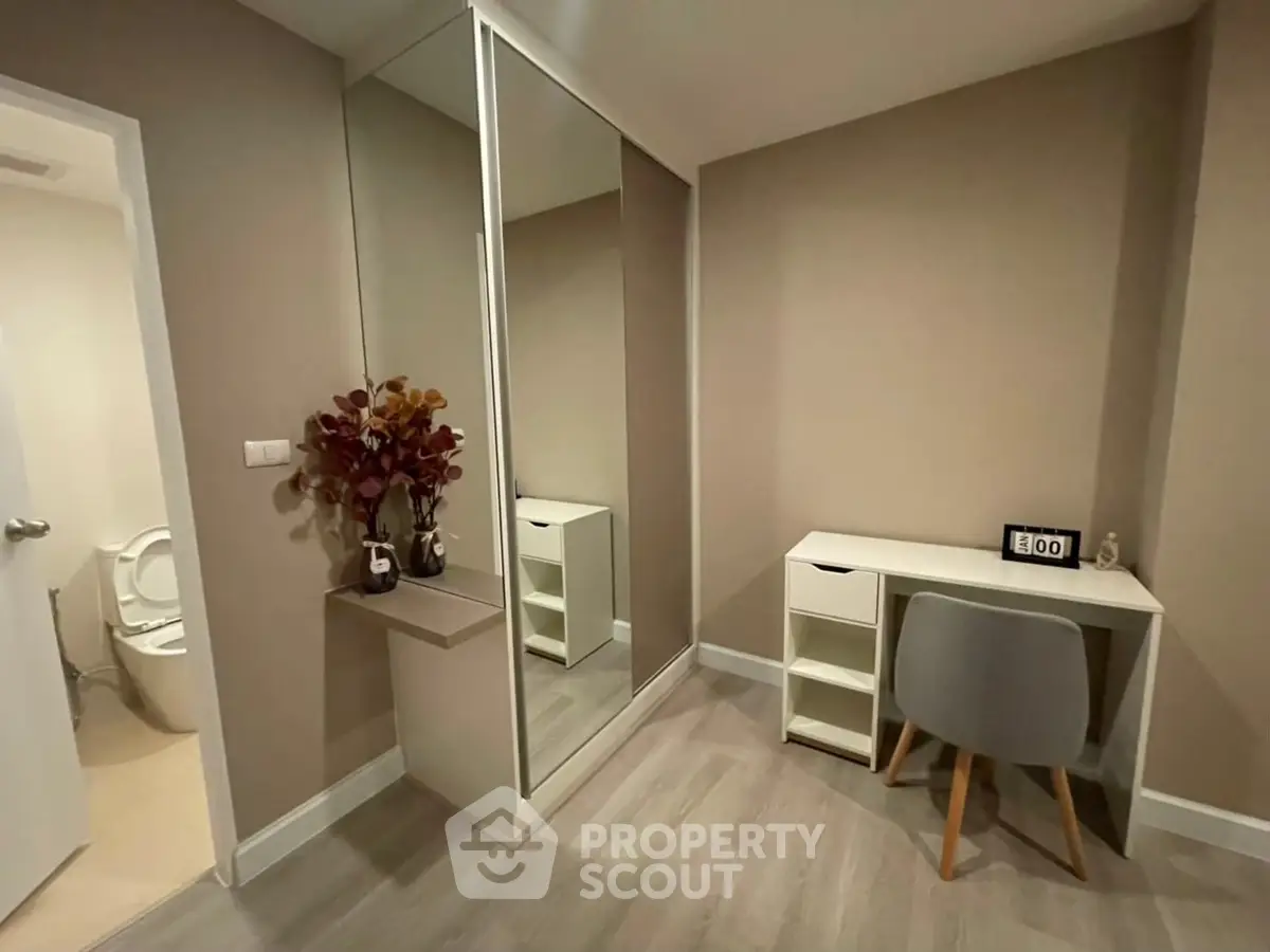 Cozy study nook with modern desk and mirrored wardrobe in a stylish apartment.