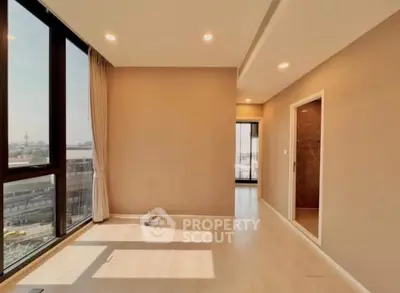 Spacious sunlit room with large windows and modern design in urban apartment.