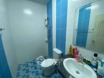 Modern bathroom with blue tiles and sleek fixtures