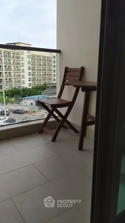 Charming balcony with city view and cozy seating area.