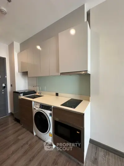 Modern compact kitchen with sleek cabinets and built-in appliances