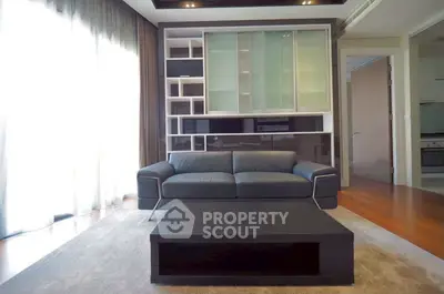 Modern living room with sleek black sofa and stylish shelving unit