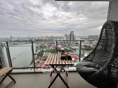 Stunning balcony view with cozy seating overlooking cityscape and river.