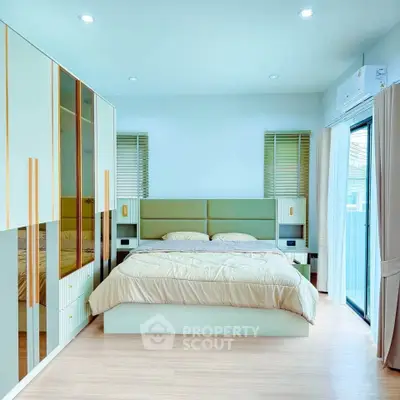 Modern bedroom with stylish decor and ample natural light, featuring a cozy bed and built-in wardrobe.