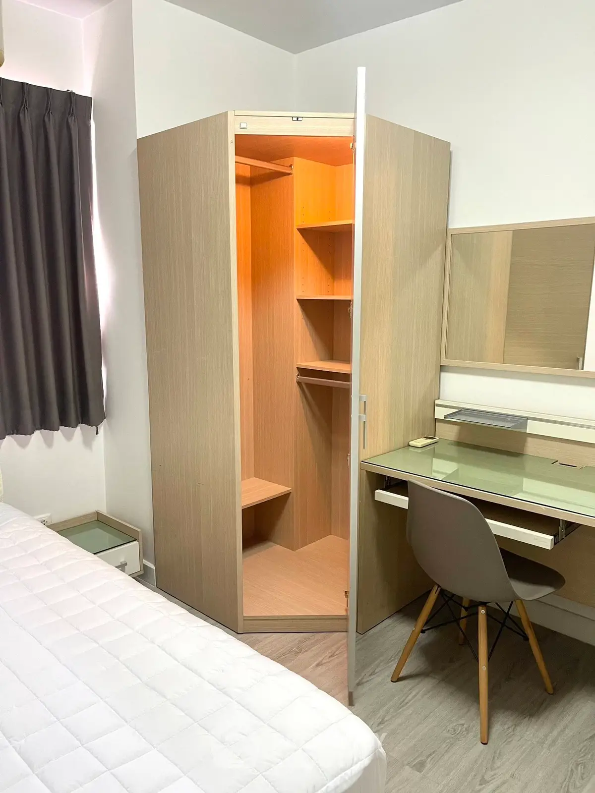Modern bedroom with built-in corner wardrobe and sleek desk setup