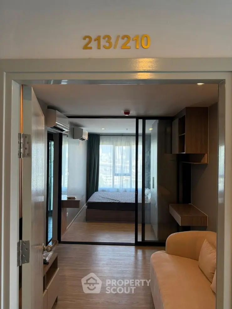 Modern apartment interior with open living area and bedroom view
