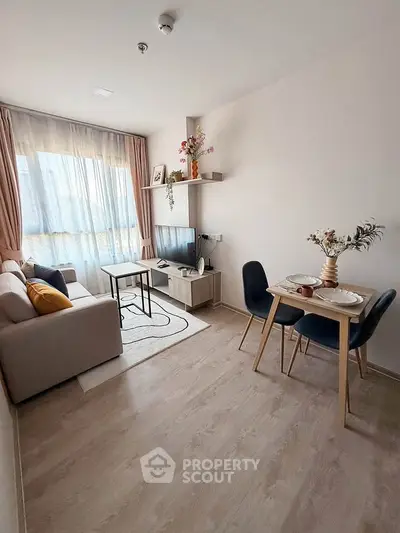 Modern living room with cozy seating and dining area, featuring stylish decor and natural light.