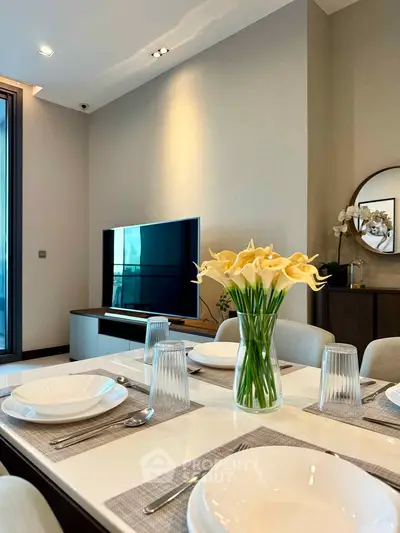 Elegant dining area with modern decor and TV, perfect for stylish living.
