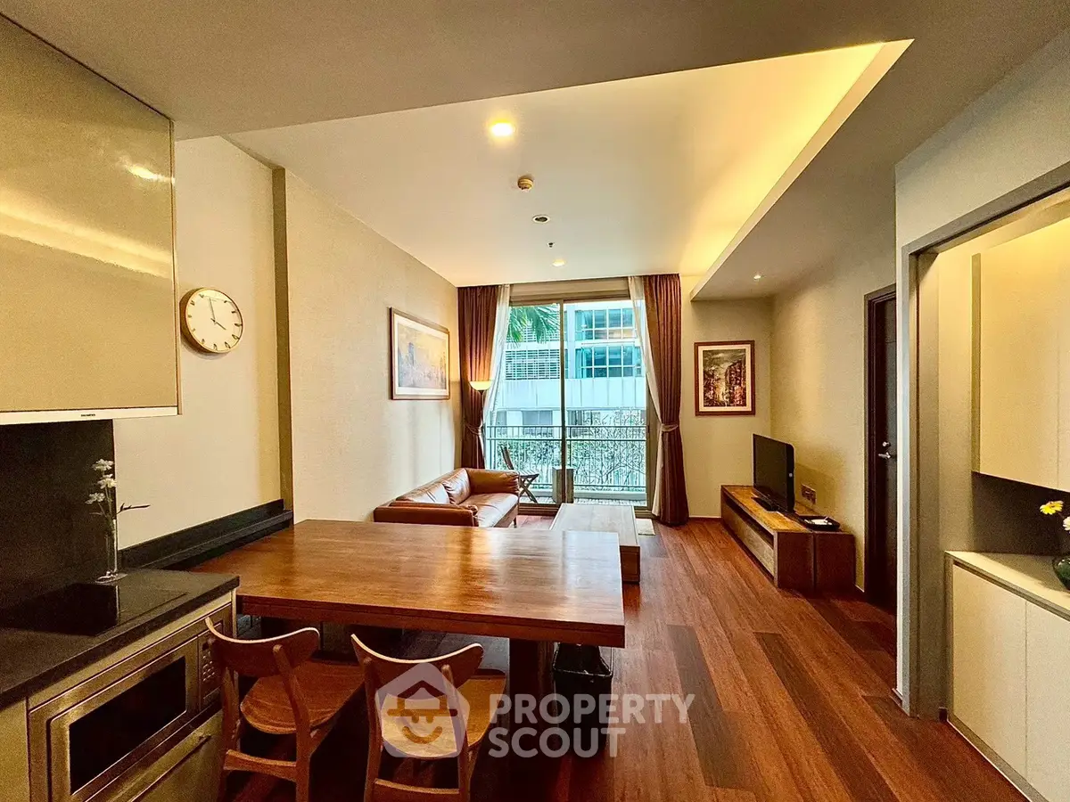 Modern living room with open kitchen and wooden flooring in a stylish apartment.