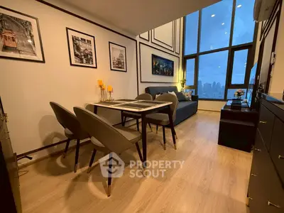 Modern living room with stylish decor and city view, featuring elegant dining area and cozy seating.