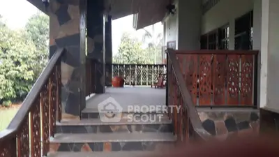 Charming exterior view of a rustic home with stone steps and decorative wooden railings.