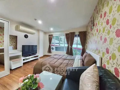 Cozy bedroom with floral wallpaper, large window, and modern furnishings in a stylish apartment.