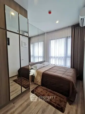 Modern bedroom with mirrored wardrobe and large windows for natural light