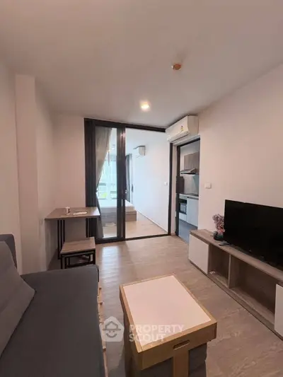 Modern living room with sleek furniture and balcony view in a stylish apartment.