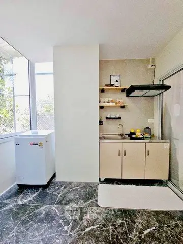 Modern kitchen with sleek design and natural light, featuring compact appliances and stylish shelving.