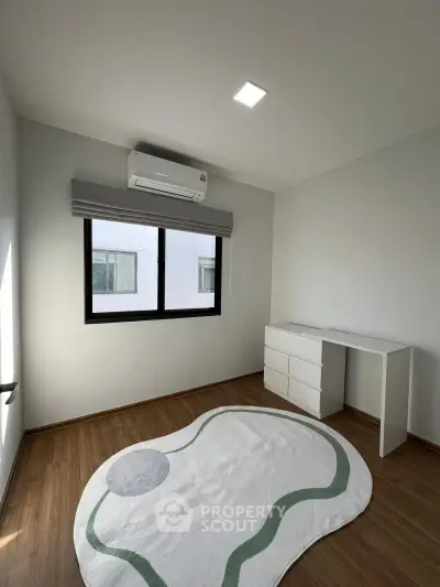 Minimalist bedroom with air conditioning and modern decor in a bright, spacious apartment.