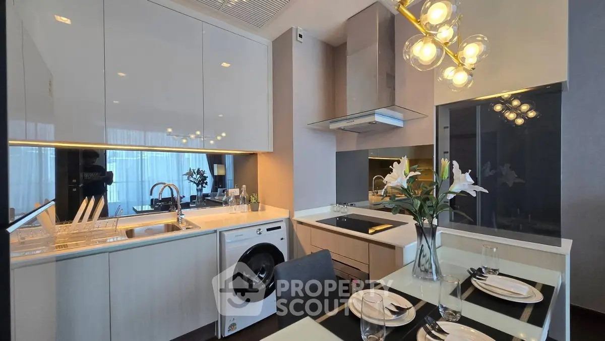 Modern kitchen with sleek cabinets, dining table, and built-in appliances.