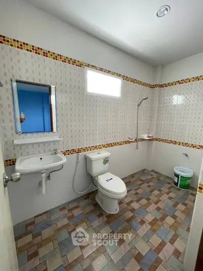 Spacious bathroom with modern fixtures and colorful tile flooring.