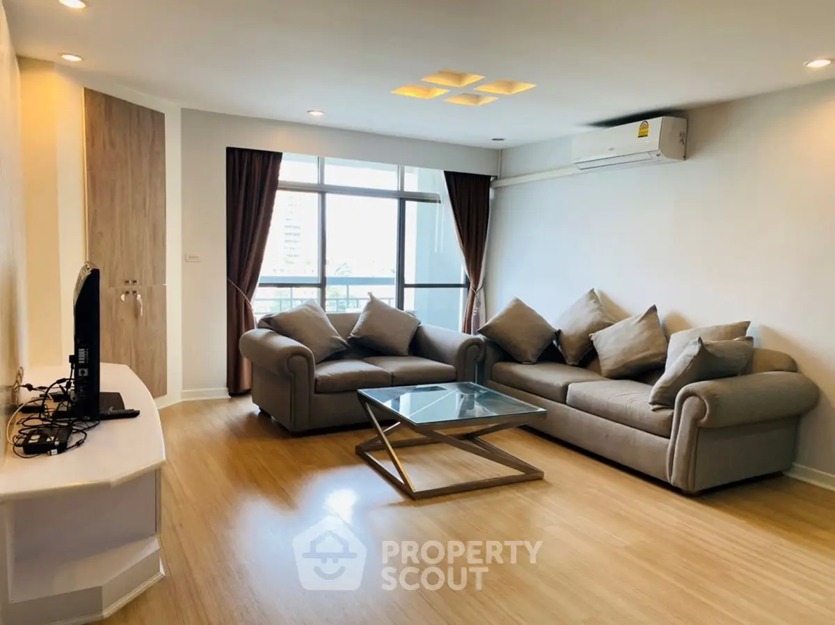 Spacious living room with modern furniture and large windows offering natural light.