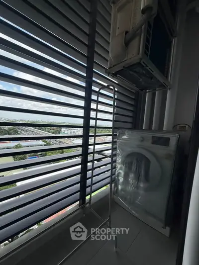 High-rise balcony with city view and air conditioning unit, perfect for urban living.
