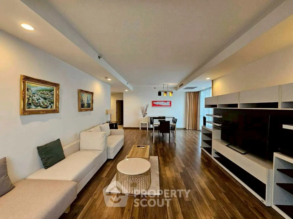 Spacious modern living room with elegant decor and open layout, featuring hardwood floors and stylish furniture.