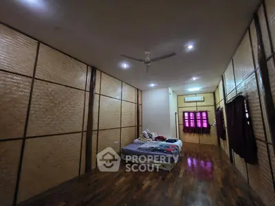 Spacious bedroom with wooden flooring and cozy lighting