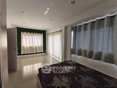 Spacious bedroom with large windows and elegant curtains in modern home