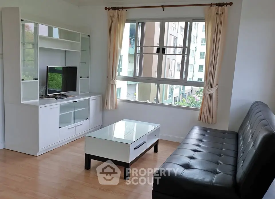 Bright living room with modern furnishings and large window view
