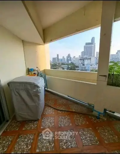 Spacious balcony with city skyline view, perfect for relaxation and enjoying urban living.