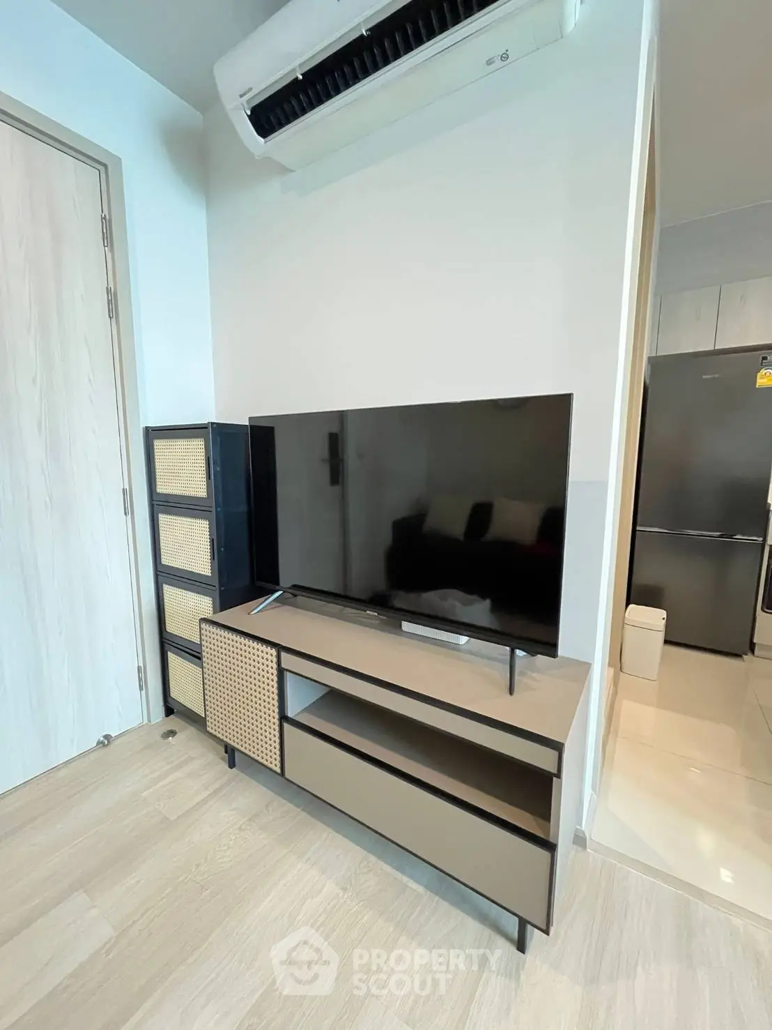 Modern living room with sleek TV stand and air conditioning, showcasing contemporary interior design.