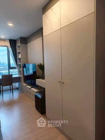 Modern living room with city view, sleek furniture, and ample storage space.