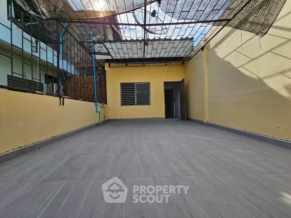 Spacious rooftop terrace with tiled flooring and partial shade, perfect for outdoor relaxation.