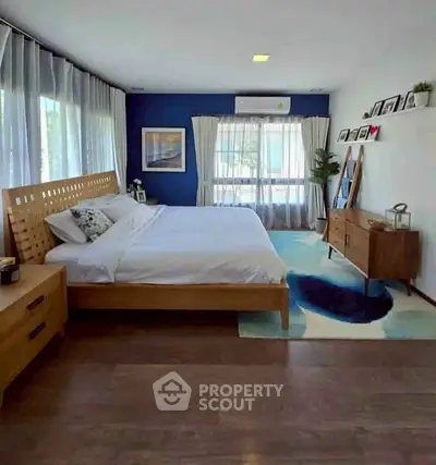 Spacious modern bedroom with wooden furniture and large windows