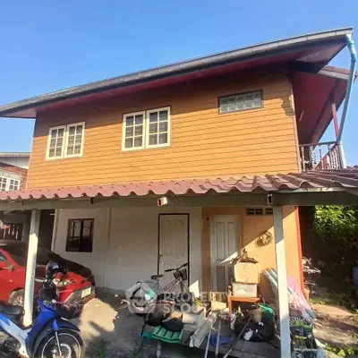 Charming two-story house with parking space and outdoor storage area, perfect for family living.