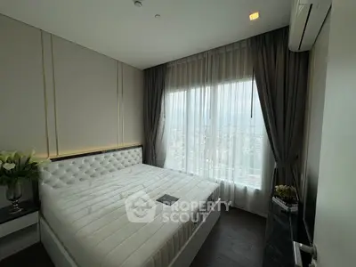 Luxurious bedroom with city view, elegant decor, and plush bedding in modern apartment.