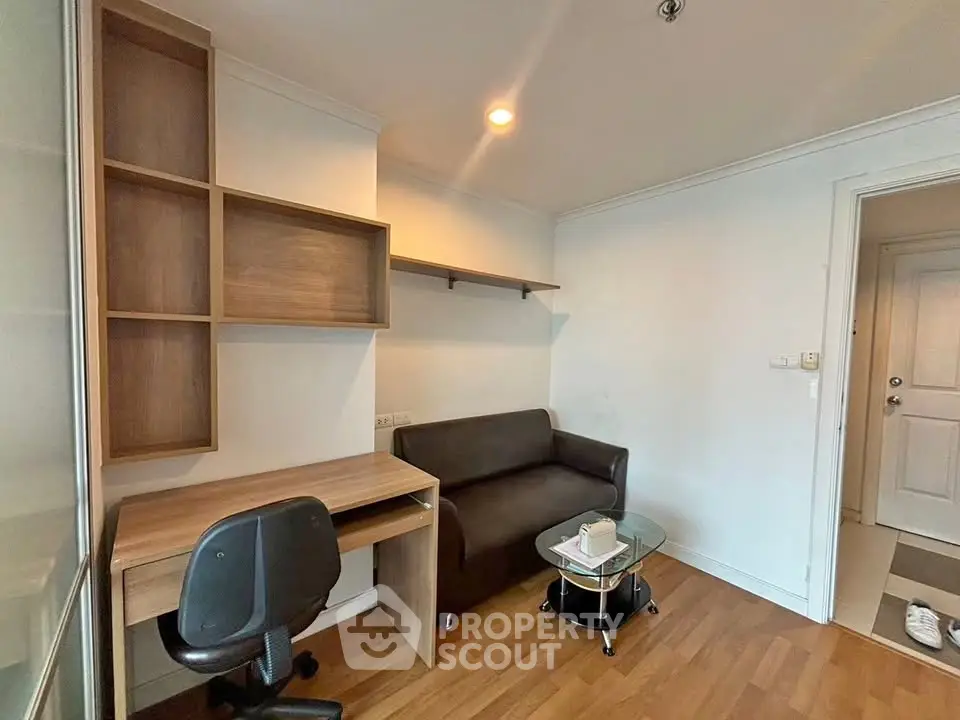 Cozy study area with modern desk and comfortable seating in a stylish apartment.