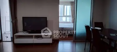 Modern apartment interior with TV, dining area, and bedroom view