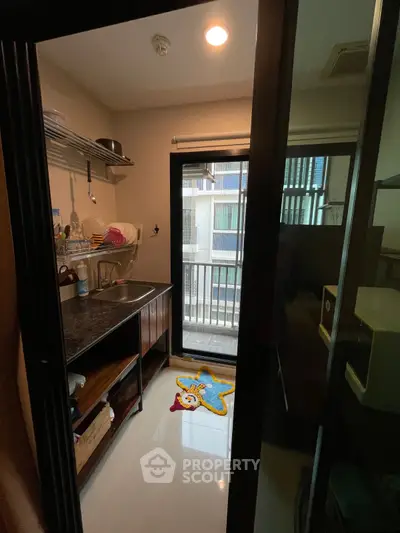 Compact kitchen with open layout and balcony access in modern apartment