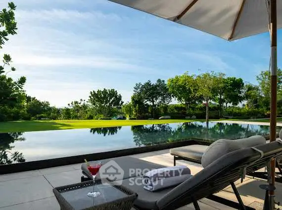 Luxurious poolside view with lush greenery and relaxing lounge chairs.