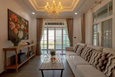 Elegant living room with chandelier, large sofa, and stylish decor in a modern home.