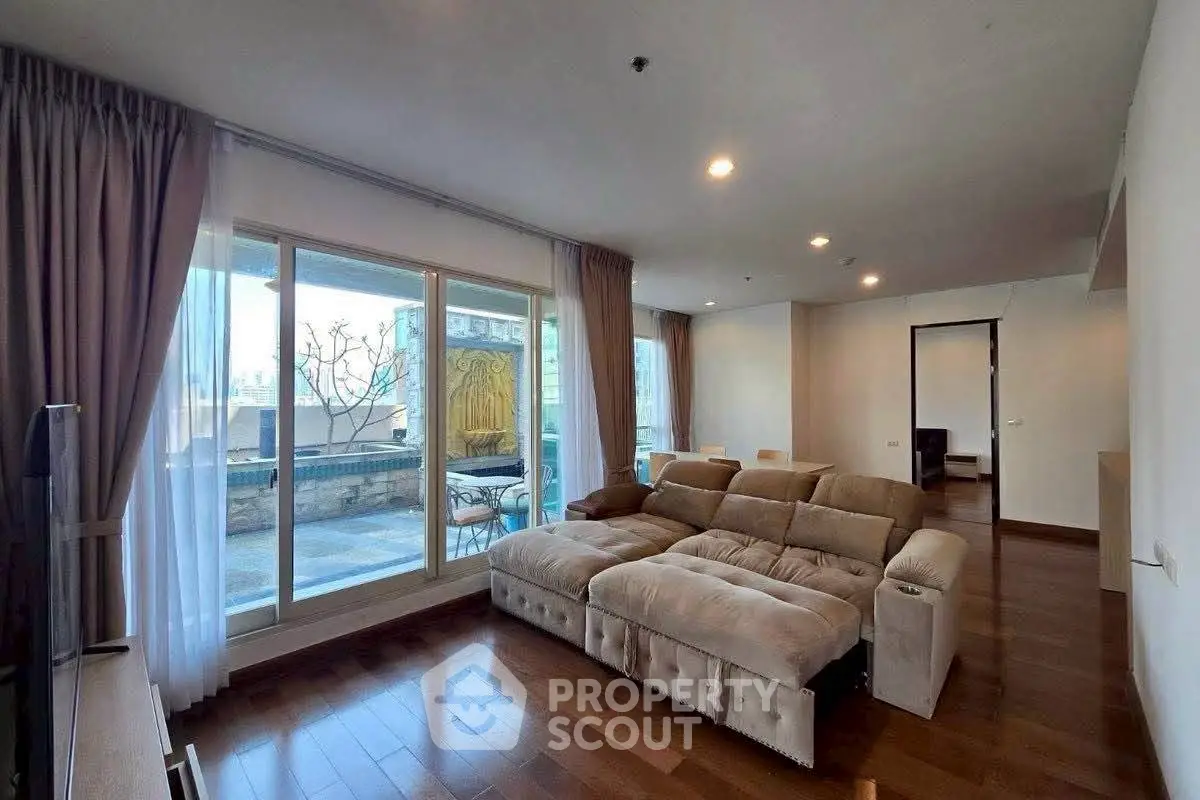 Spacious living room with large windows and outdoor balcony access