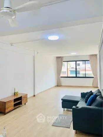 Spacious living room with modern sofa and natural light, perfect for relaxation and entertainment.
