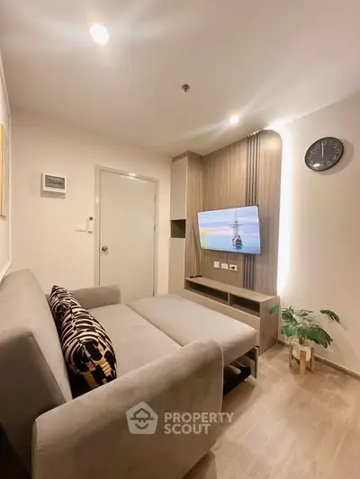 Modern living room with sleek design, featuring a comfortable sofa and wall-mounted TV for ultimate relaxation.