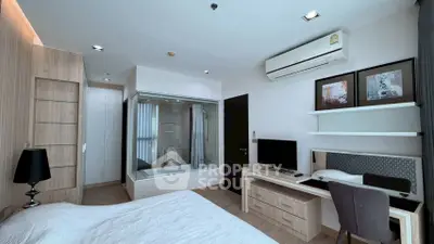 Modern bedroom with built-in bathtub and stylish workspace, featuring sleek design and natural light.